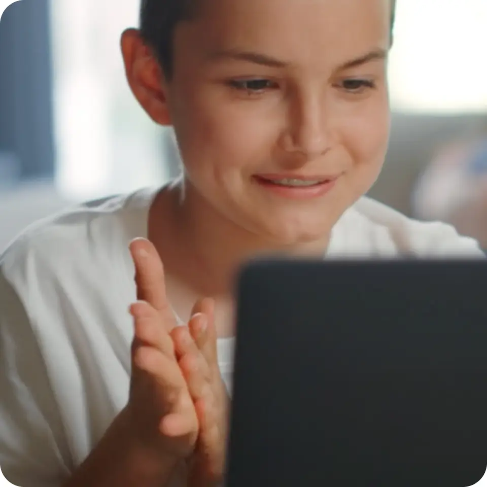 A smiling student looking at a laptop screen during a lesson.
